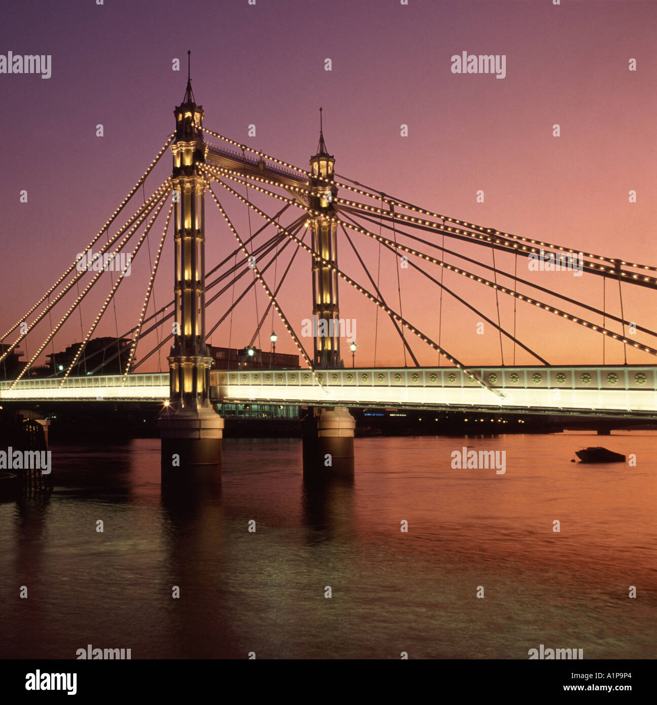 Sonnenuntergang und Licht in der Dämmerung auf der historischen viktorianischen Albert Bridge verbindet Chelsea im Norden mit Battersea im Süden der Themse London England Großbritannien Stockfoto