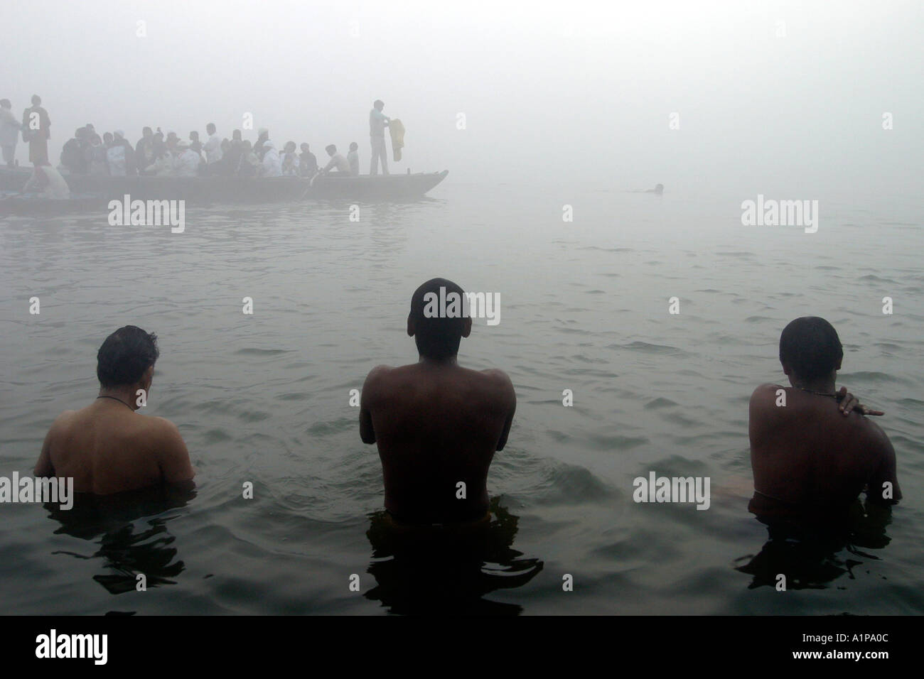 Männer nehmen eine religiöse Bad zu reinigen ihre Seelen von vergangenen Sünden in den heiligen Fluss Ganges in der Stadt Varanasi in Nordindien Stockfoto