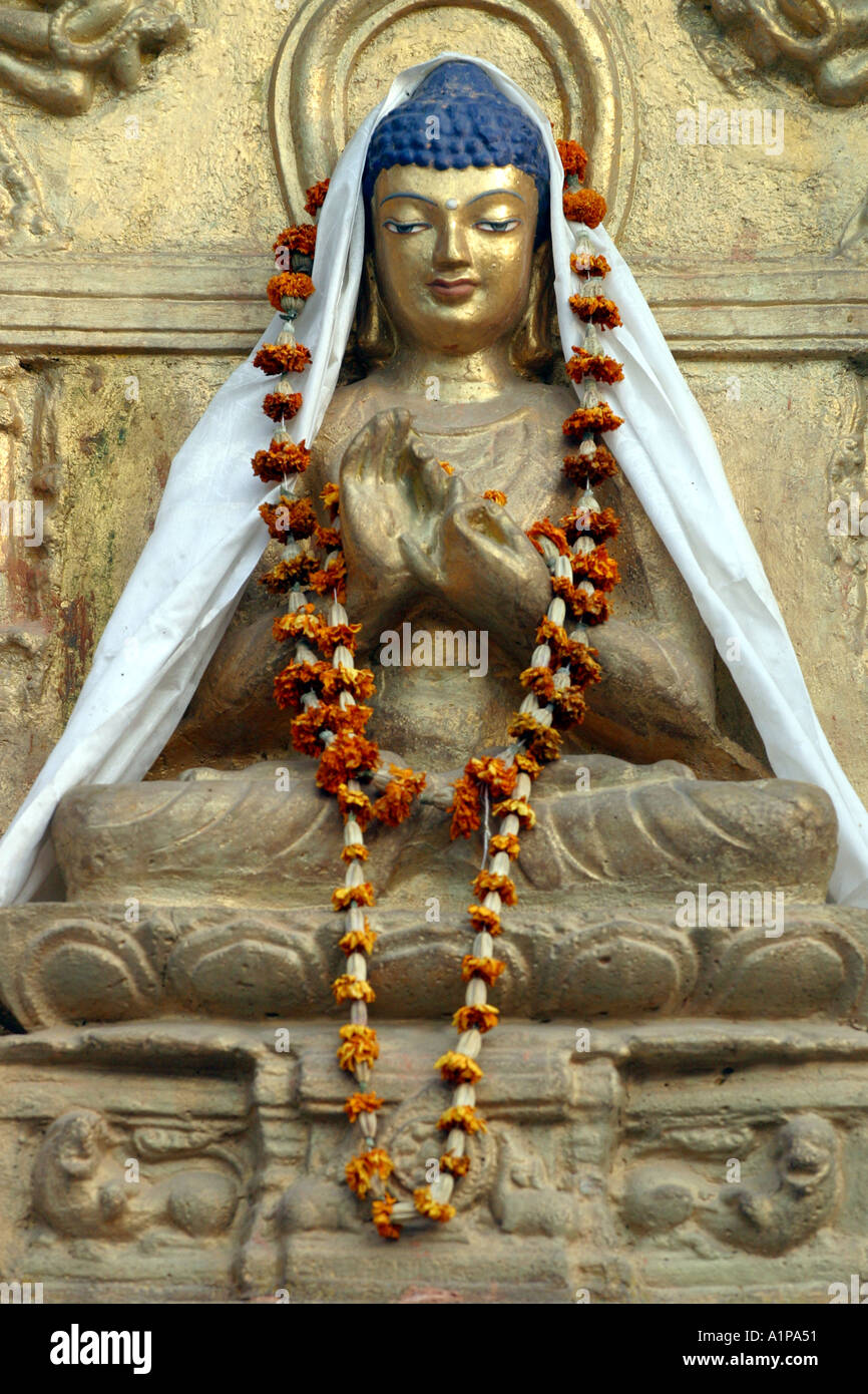 Eine Buddha-Statue ist mit einer Blumengirlande in der Nähe der Mahabodhi-Tempel in Bodhgaya in Bihar in Indien eingerichtet. Stockfoto