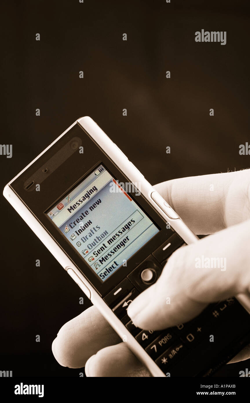 Hand mit Mobiltelefon eine SMS-Nachricht senden Stockfoto