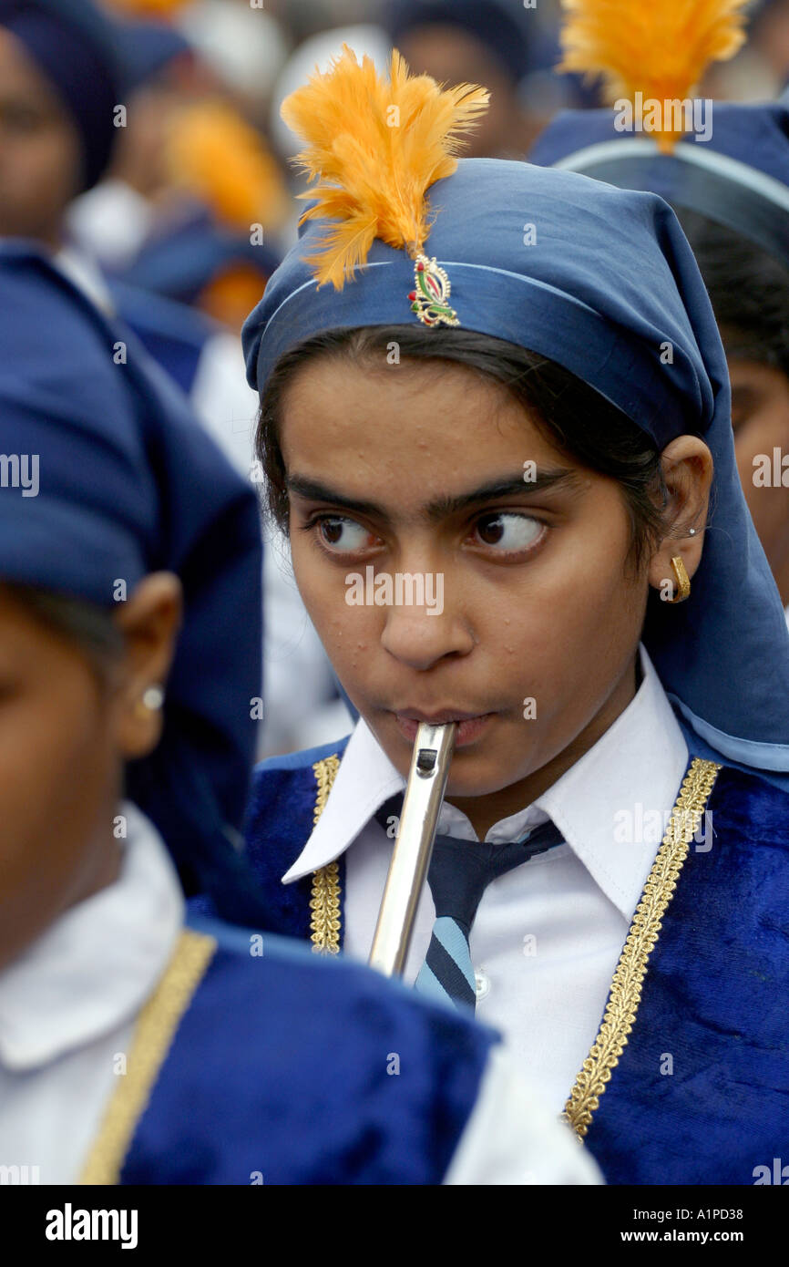 Eine indische Sikh Mädchen spielt eine Querflöte während einer Prozession Straße in Delhi in Indien Stockfoto