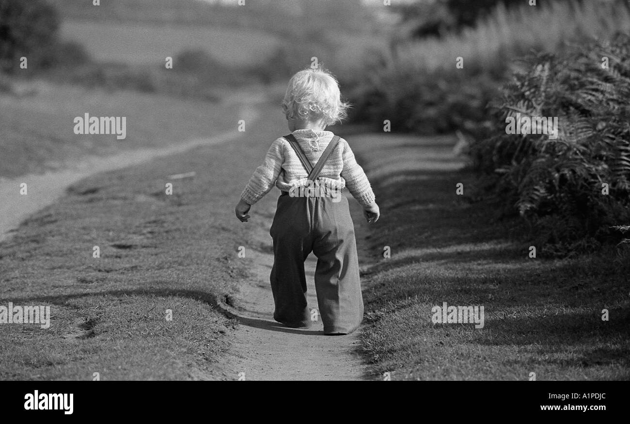 Kleiner Junge in der ersten Woche zu Fuß in knapp über ein Jahr alt, auf einem Feldweg. Stockfoto