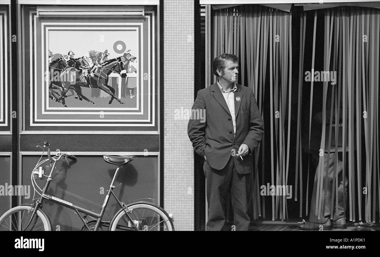 Mann in Wetten Shop Eingang mit Fahrrad gegen die Wand. Stockfoto