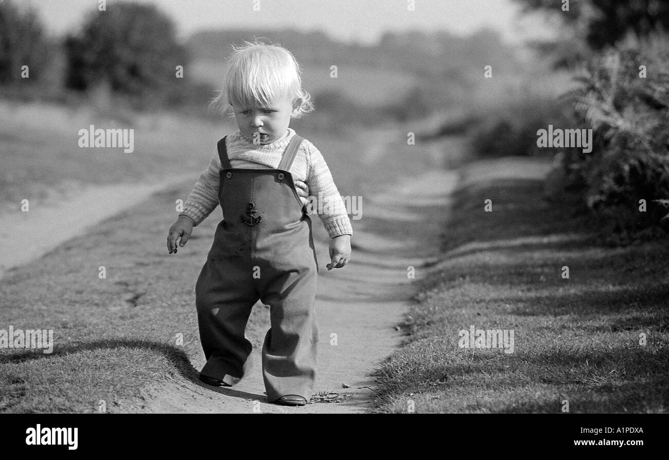 Kleiner Junge in der ersten Woche zu Fuß in knapp über ein Jahr alt, auf einem Feldweg. Stockfoto