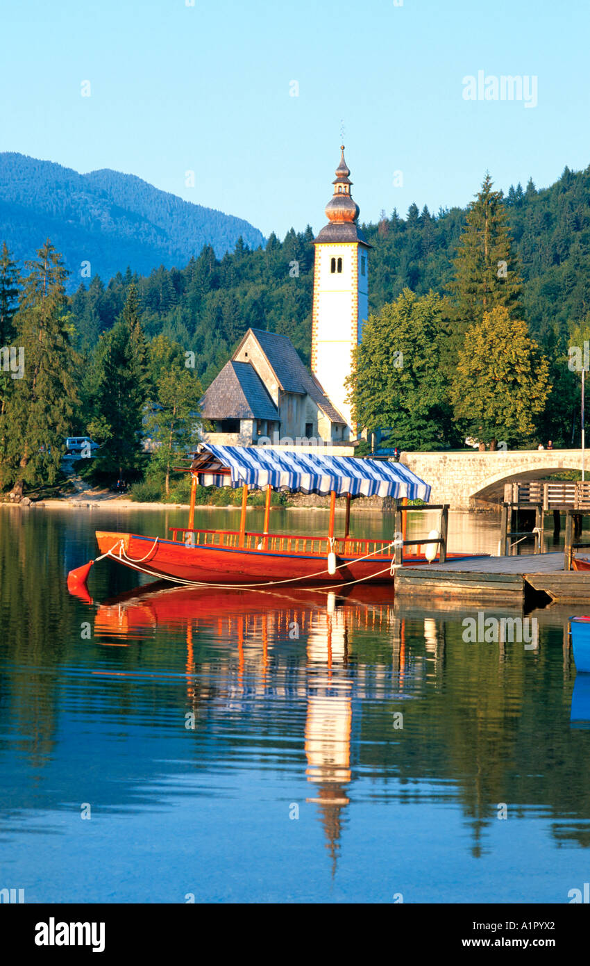St. Johanneskirche und typischen Boot am See Bohinj Ribzev Laz Bohinj Slowenien Stockfoto