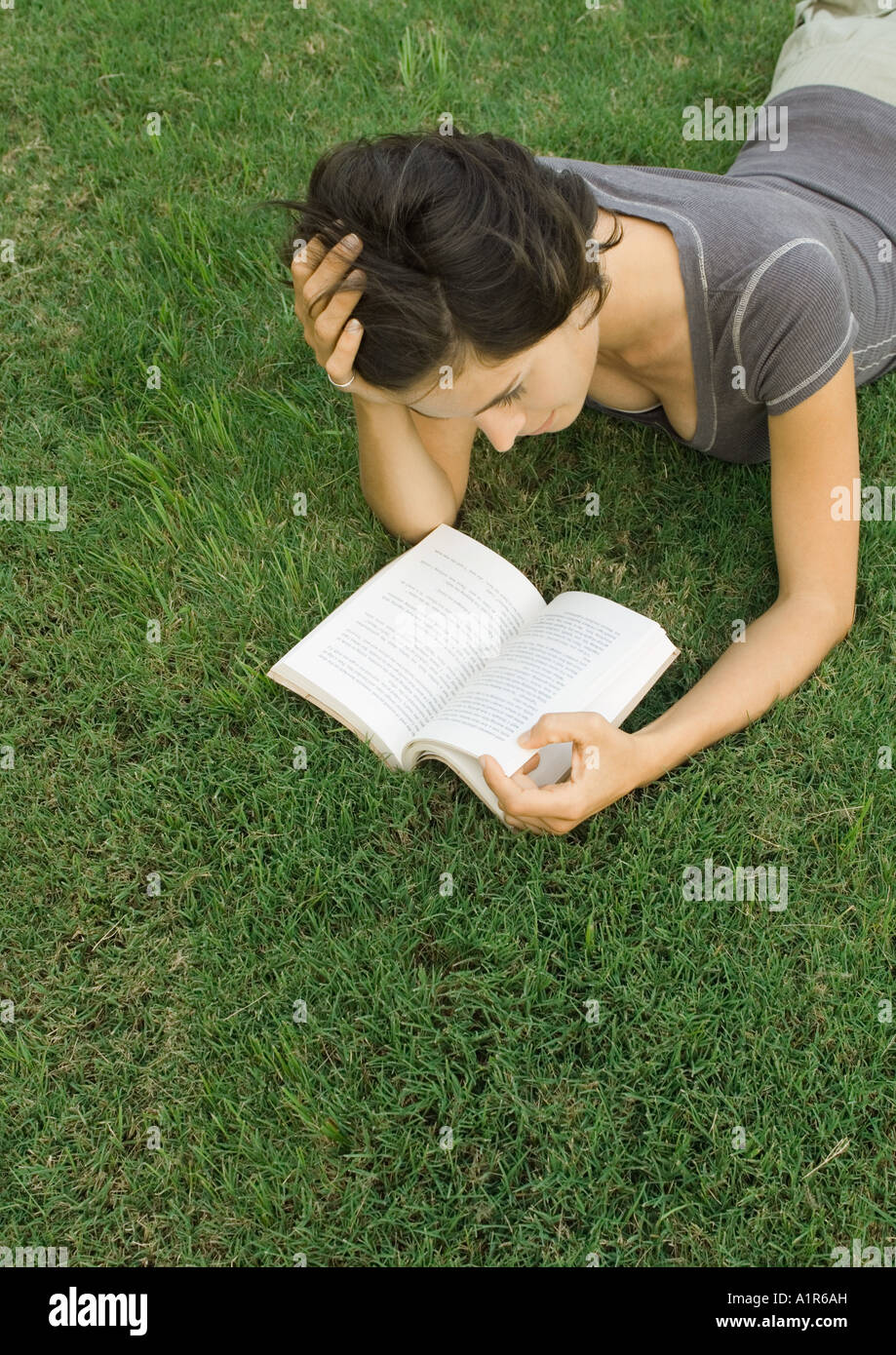 Frau liegend auf Rasen, Buch lesen Stockfoto