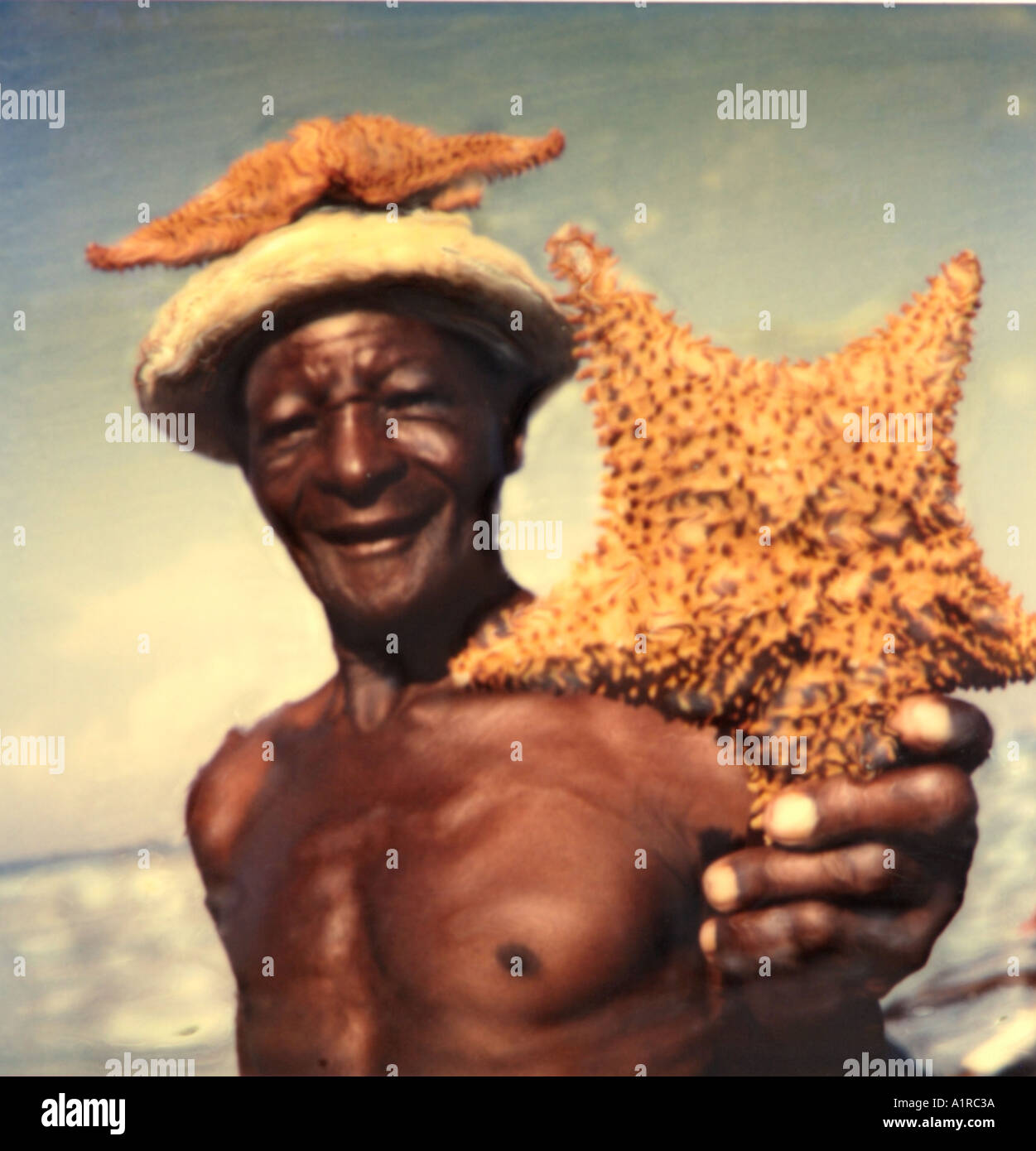 Jamaikanisch Mann Hausierhandel Seestern Polaroid SX70 manipulation Stockfoto