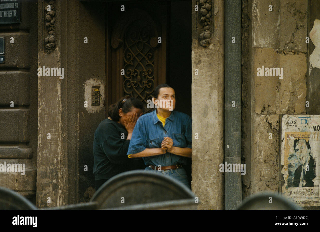 SARAJEVO JUNI 1995 ZWEI FRAUEN SCHOCKIERT BEUNRUHIGT DURCH EINEN BOMBENANGRIFF MÖRTEL AUßERHALB IHRER WOHNUNG Stockfoto