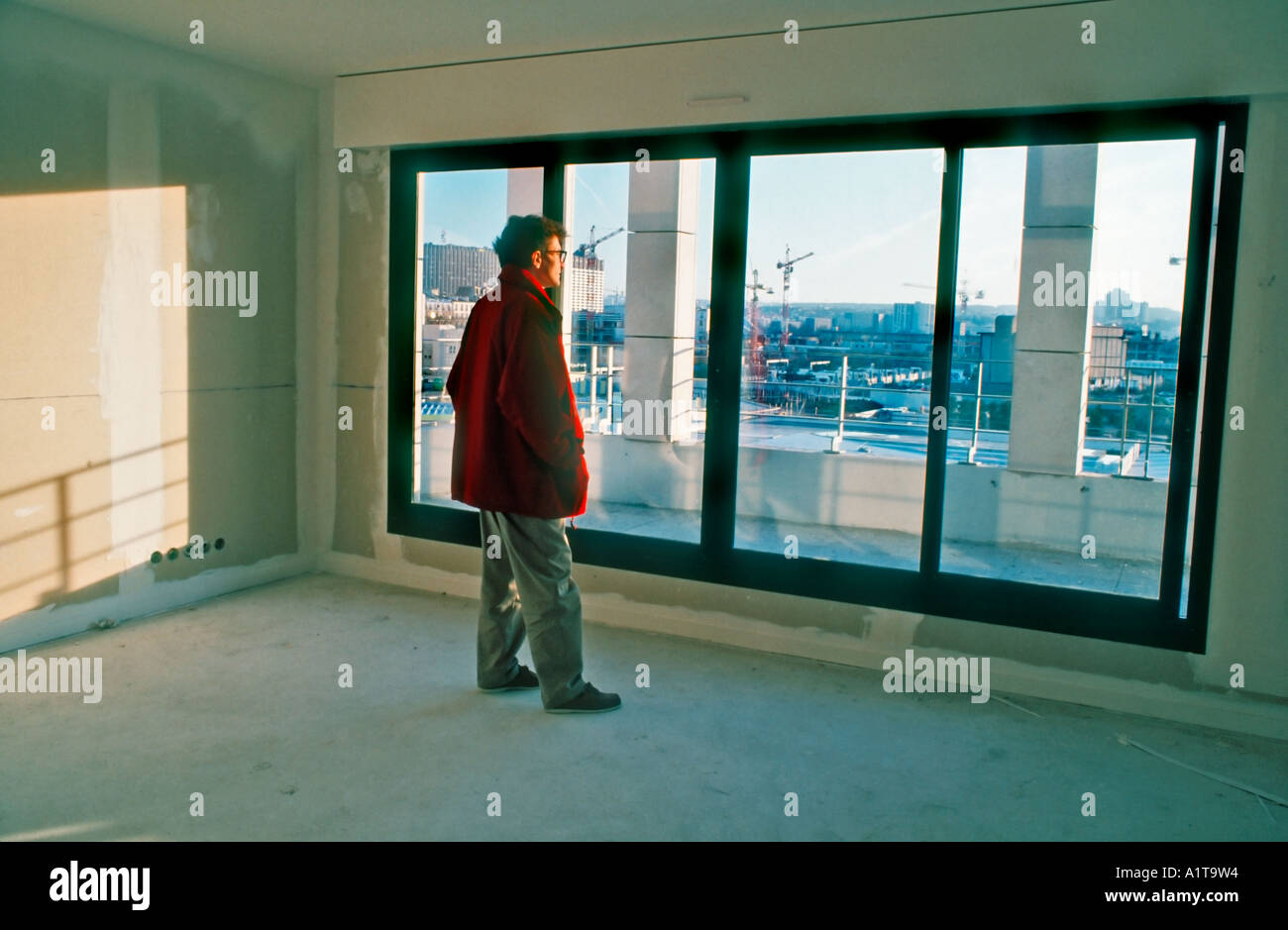 Paris Frankreich, Mann im Inneren, der aus dem Fenster blickt Stadt, beim Bau der Luxuswohnung, Neubau der Wohnungen, Wohnungsbau frankreich, Stockfoto