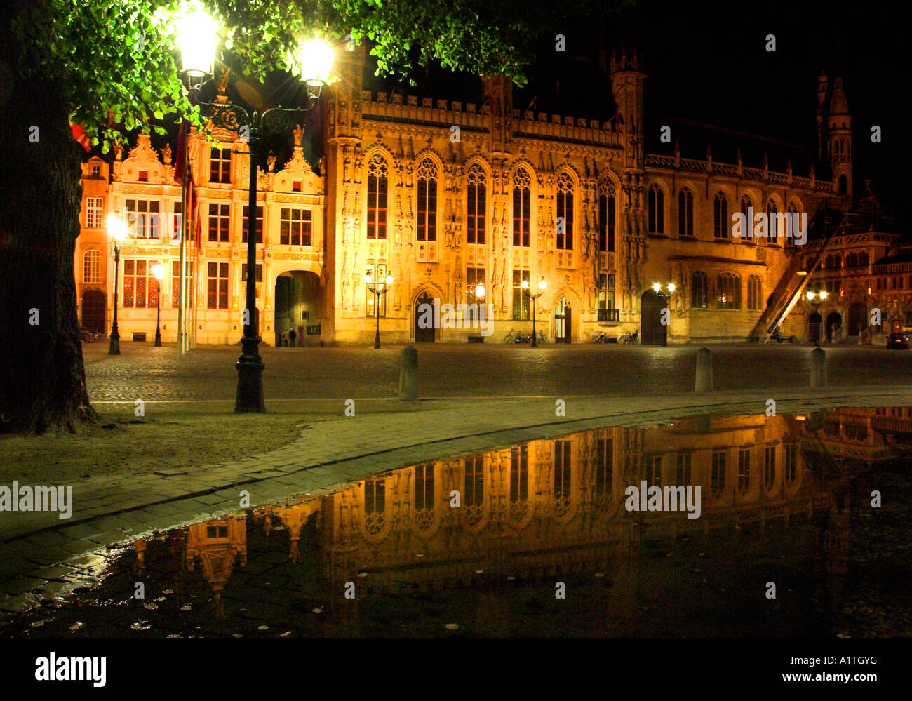 Das Rathaus von der mittelalterlichen Stadt Brügge in der Nacht spiegelt sich in einem kleinen See Stockfoto
