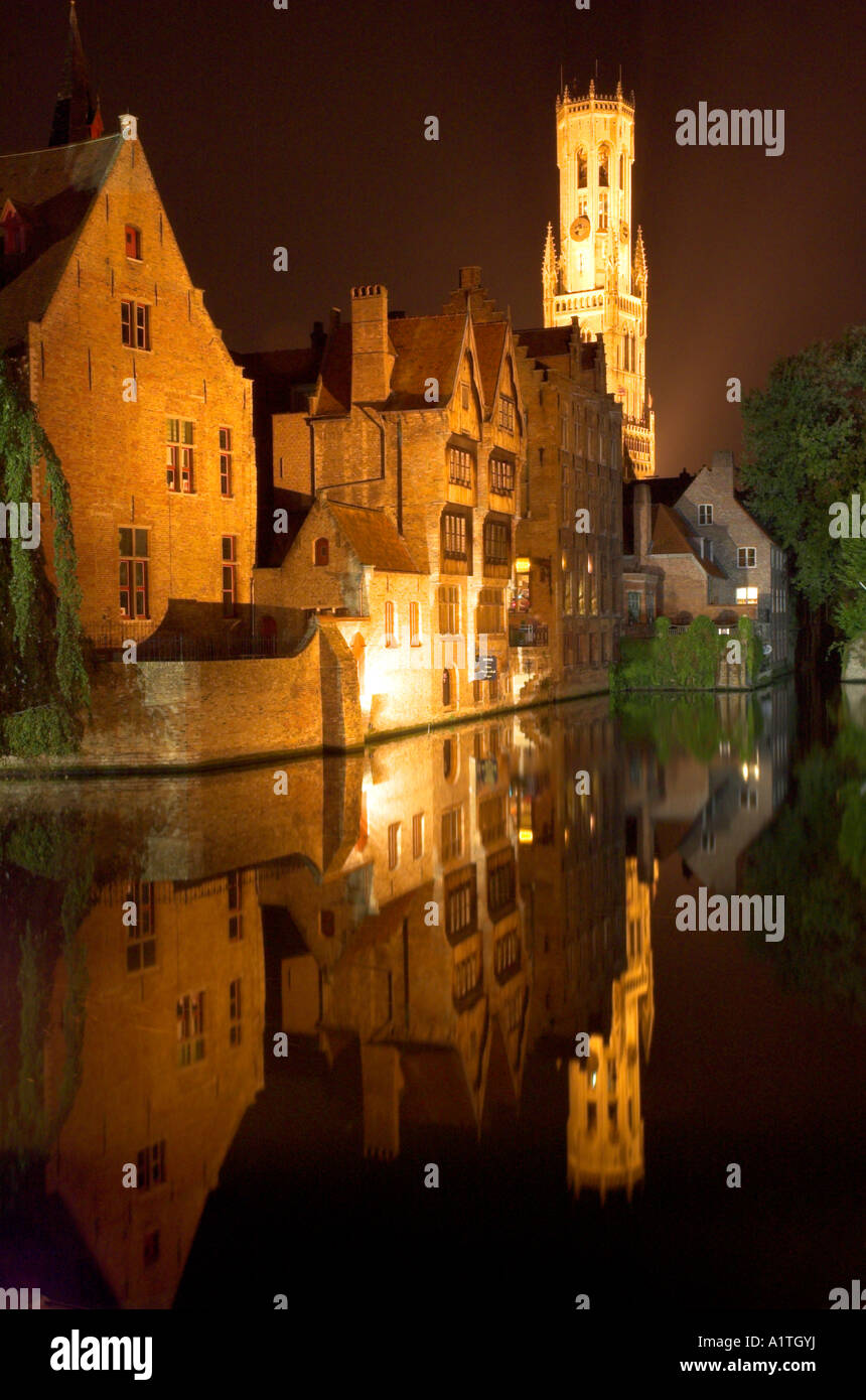 Eine nächtliche Szene der mittelalterlichen Stadt Brügge mit Glockenturm sich in den Kanal perfekt wider. Stockfoto