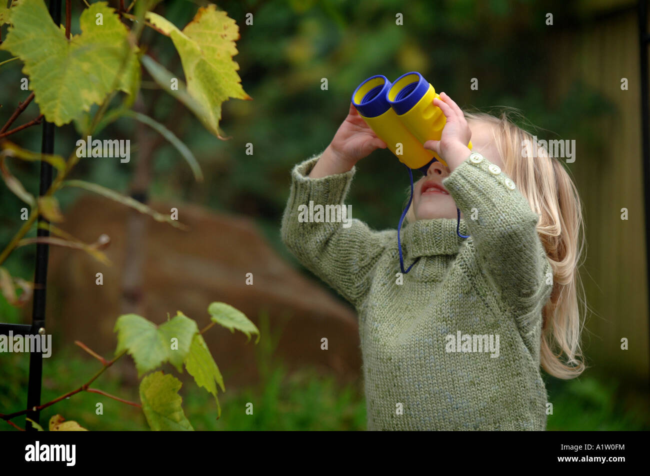 Ein kleines Kind durch ein Fernglas schauen Stockfoto