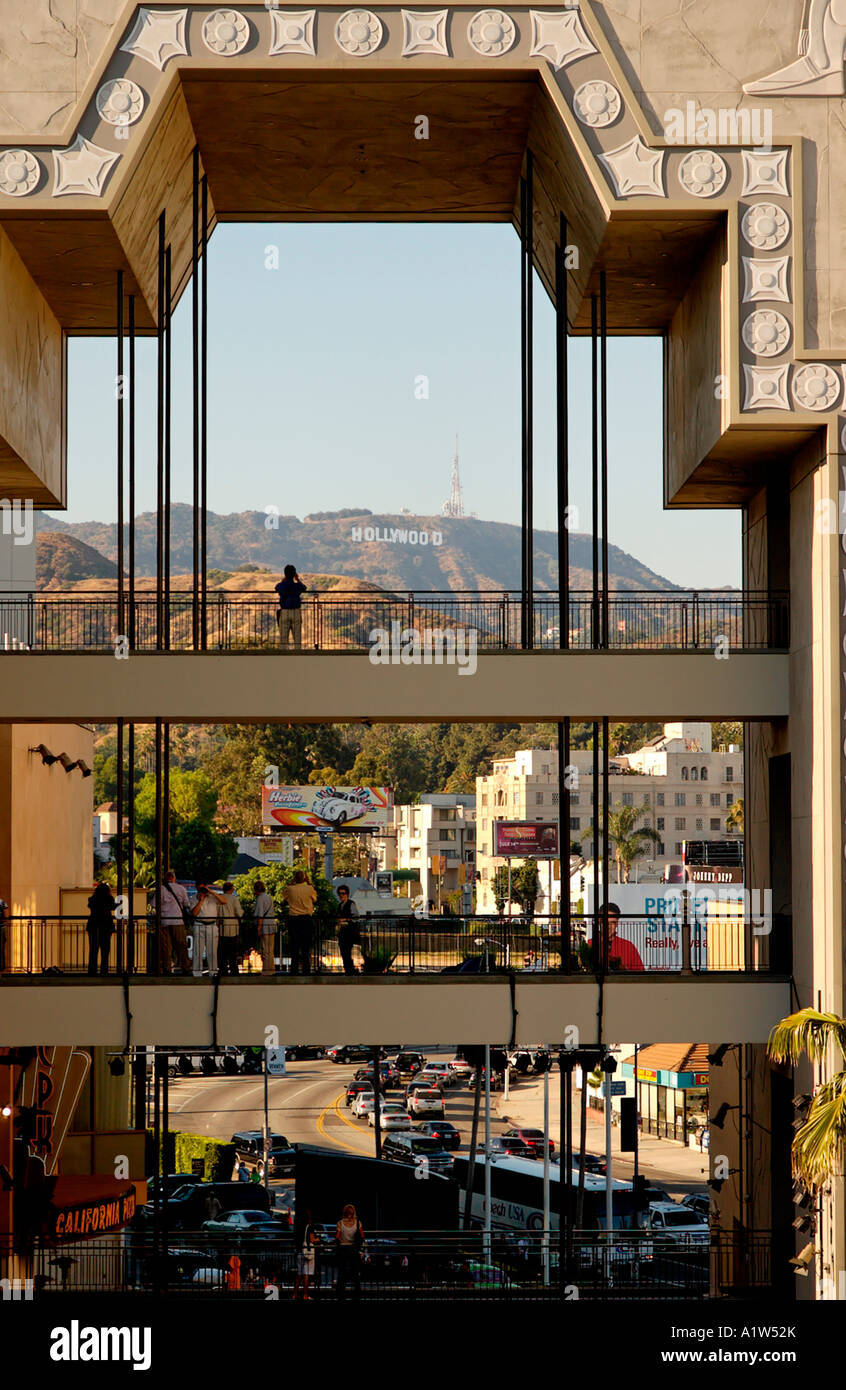 Menschen fotografieren das entfernte Hollywood-Schild von einem Gehweg am Hollywood and Highland Einkaufszentrum in Hollywood, Kalifornien, USA Stockfoto