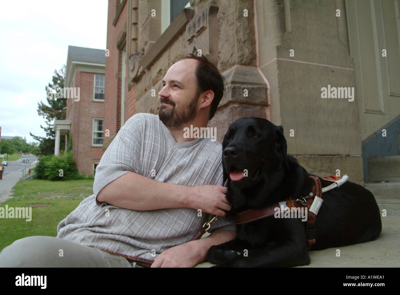 Yvan Tessier und sein sehendes Auge Hund auf Stufen der University of New Brunswick Gebäude Stockfoto