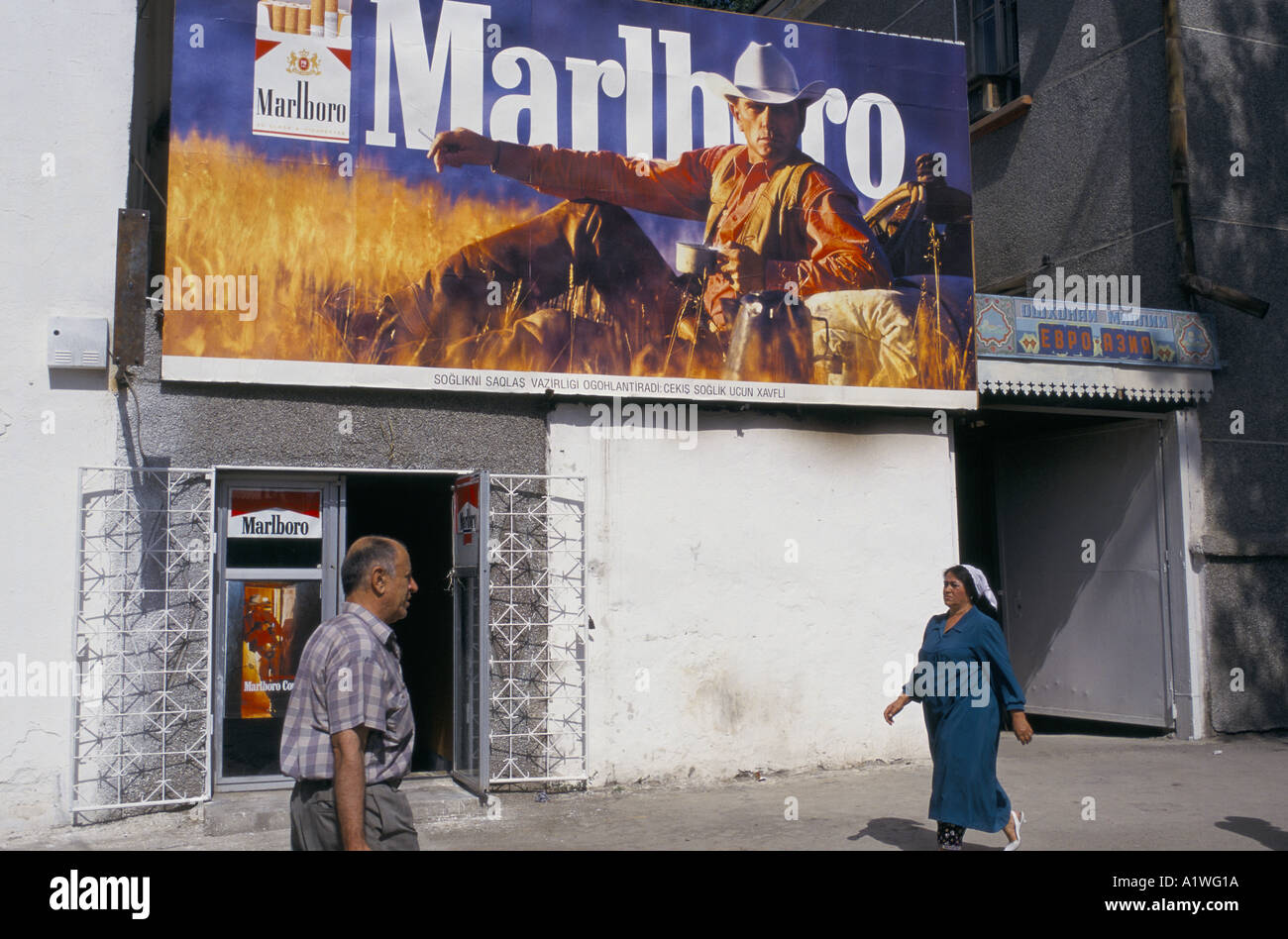 Mann und Frau zu Fuß vor einem Marlboro-Werbung, Tadschikistan Stockfoto
