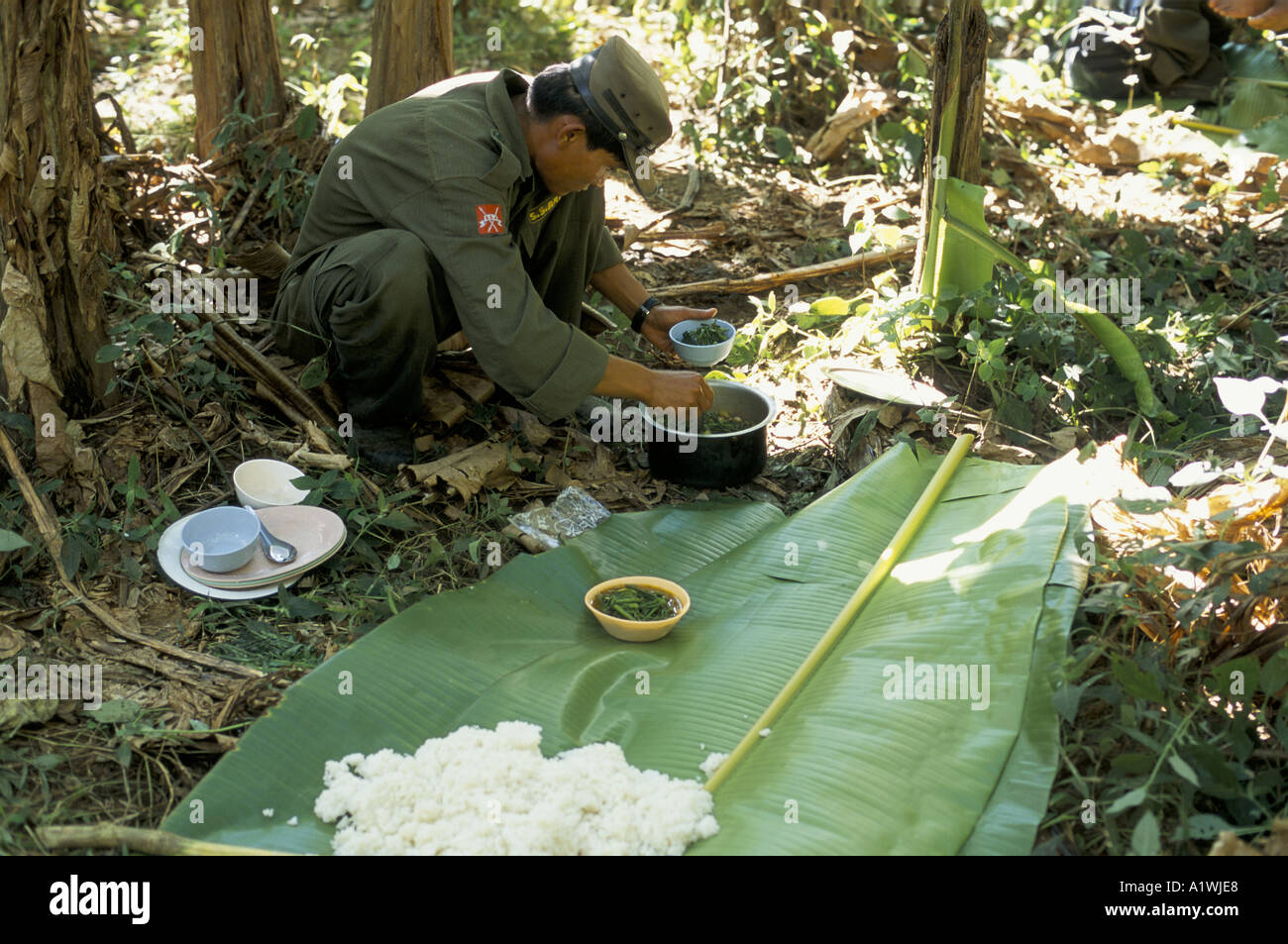 BURMA. SHAN STATE ARMY. ZUBEREITUNG EINER MAHLZEIT AUS REIS UND GEMÜSE, WÄHREND RUHEN AUF MANÖVER IN DER BURMESISCHEN HÜGEL 2001 Stockfoto