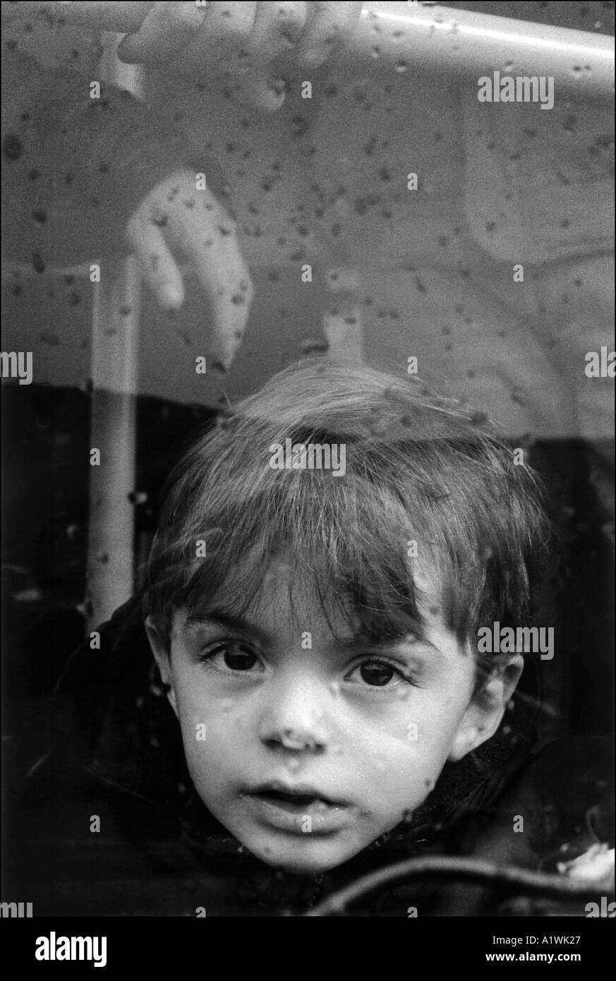 Kind schaut aus Busfenster. Sie ist mit einer Gruppe von Kosovo-Flüchtlinge an Bord Bus für die Evakuierung nach Belgien. Mazedonien 1999 Stockfoto