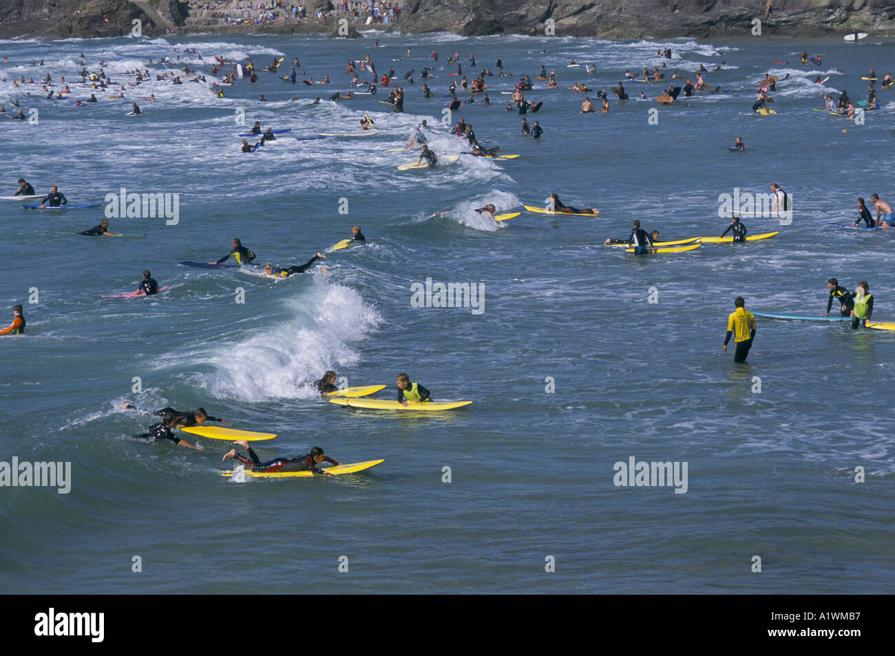 Übersicht über das Meer und die Klippen mit Surfer im Meer.  POLZEATH CORNWALL GROßBRITANNIEN 2001 Stockfoto