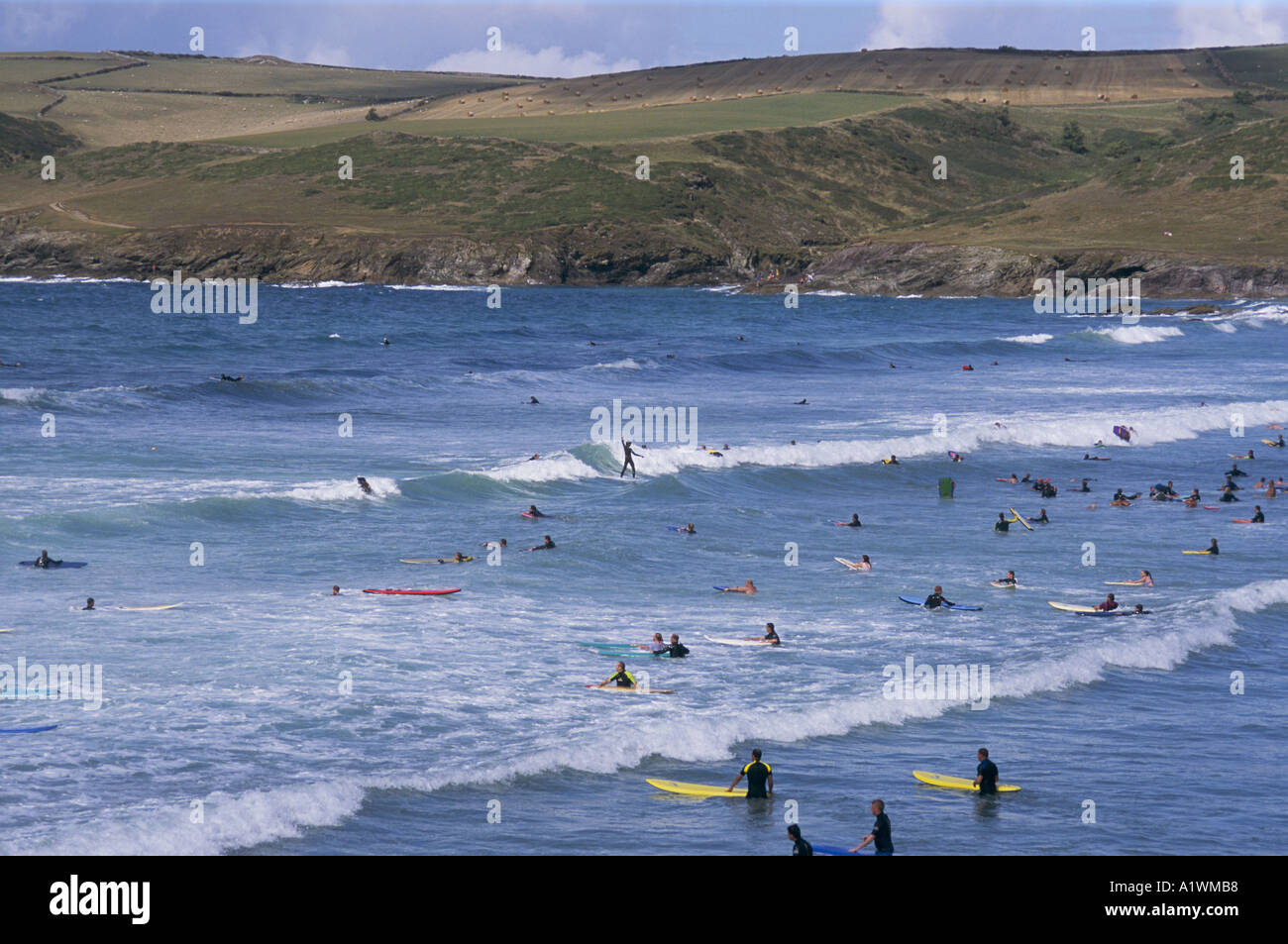 Übersicht über das Meer und die Klippen mit Surfer im Meer. POLZEATH CORNWALL GROßBRITANNIEN 2001 Stockfoto