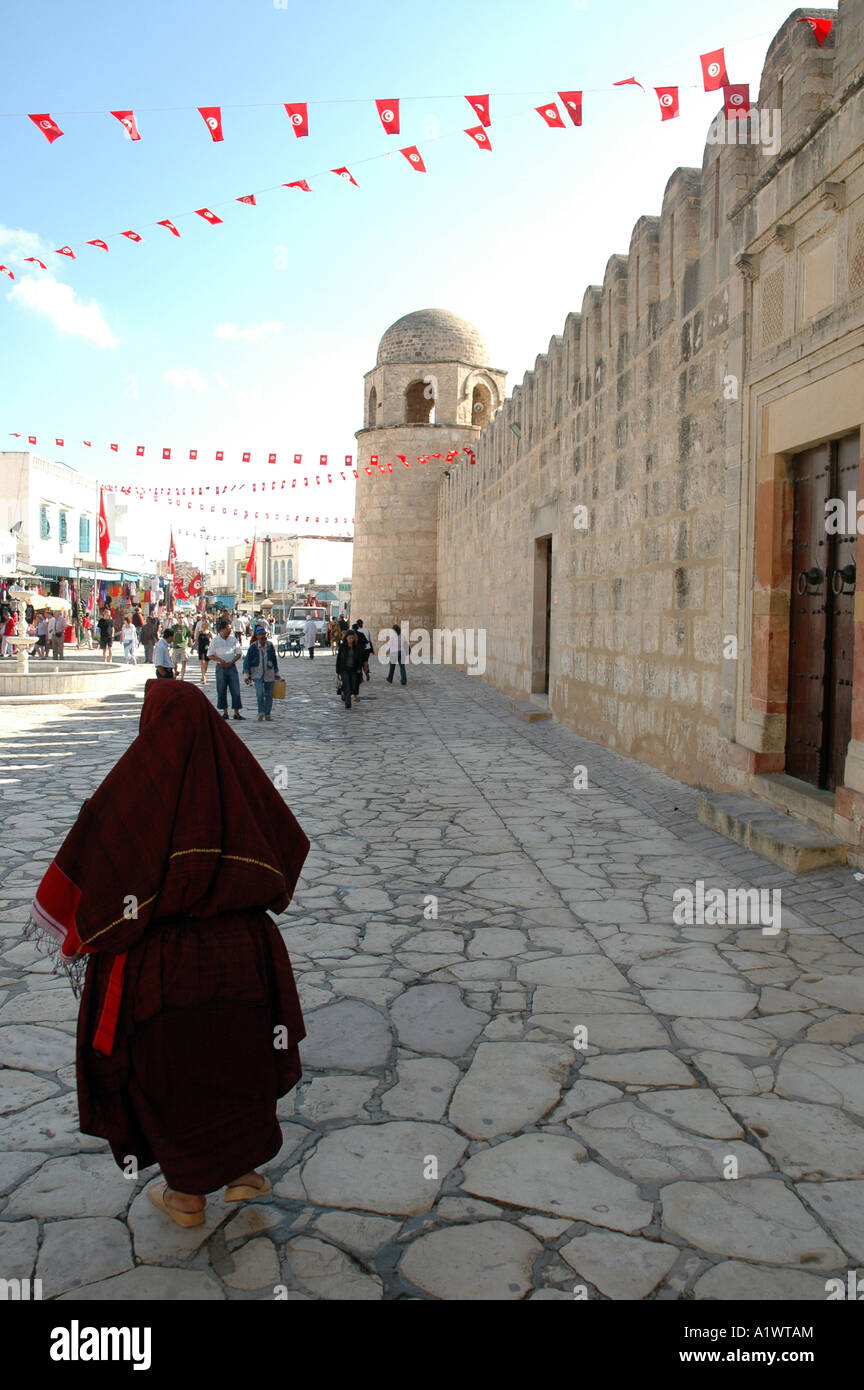 Basar auf der Medina von Sousse Stadt in Tunesien. Alten tunesischen Frau in überdachten Tracht zu Fuß neben der großen Moschee Stockfoto