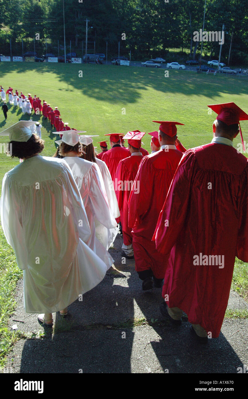 Schüler zu Fuß einen Hügel hinunter zur Abschlussfeier im freien außerhalb Stockfoto