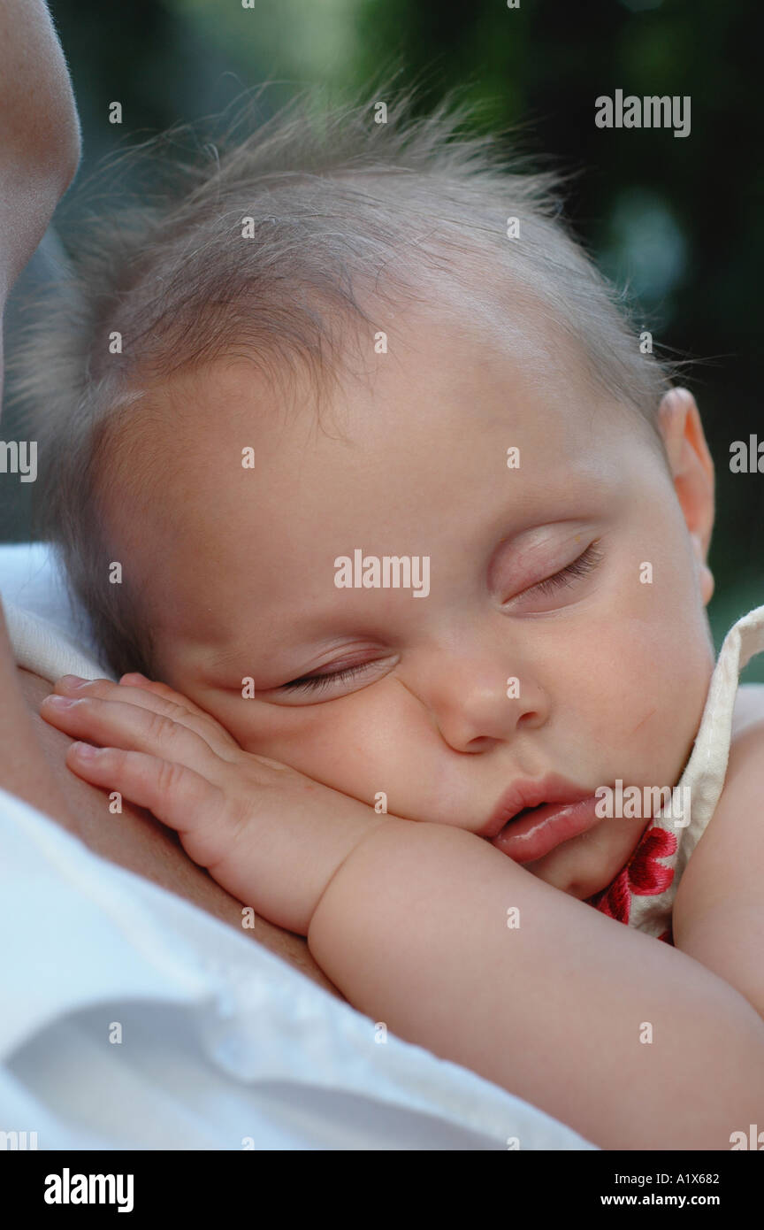 Baby schläft in Mütter Arme Augen geschlossen schlafen Mädchen Stockfoto