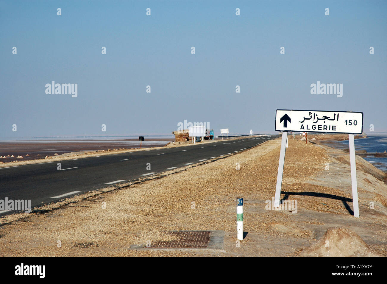 Zeichen, die Entfernung zur Grenze Algerien am Straßenrand Damm überqueren Chott el Jerid See in Tunesien informiert Stockfoto