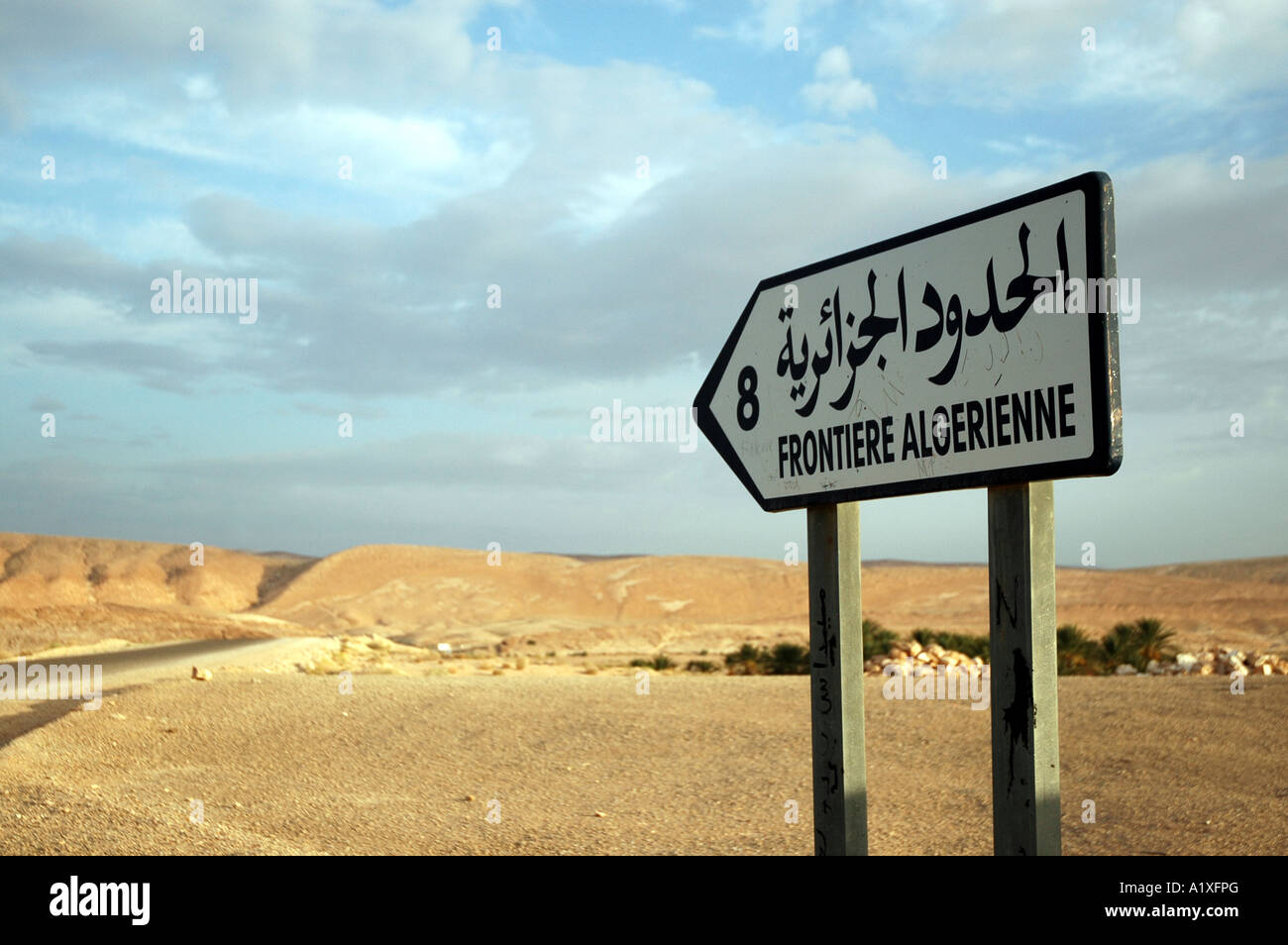 Weg von Gafsa nach Mides in Tunesien. Zeichen, die in französischen und arabischen ca. 8km Entfernung zur Grenze zwischen Tunesien und Algerien informiert Stockfoto