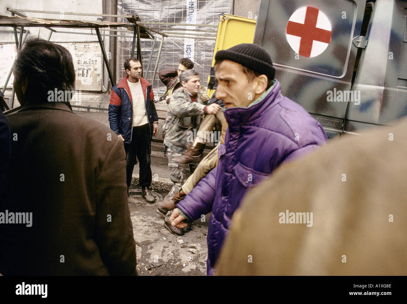 Mann mit BENOMMEN Ausdruck auf seinem Gesicht vorbei gehen MILITÄR KRANKENWAGEN GELADEN mit dem Körper nach dem Massaker auf dem Marktplatz in Sarajevo 1994 Stockfoto