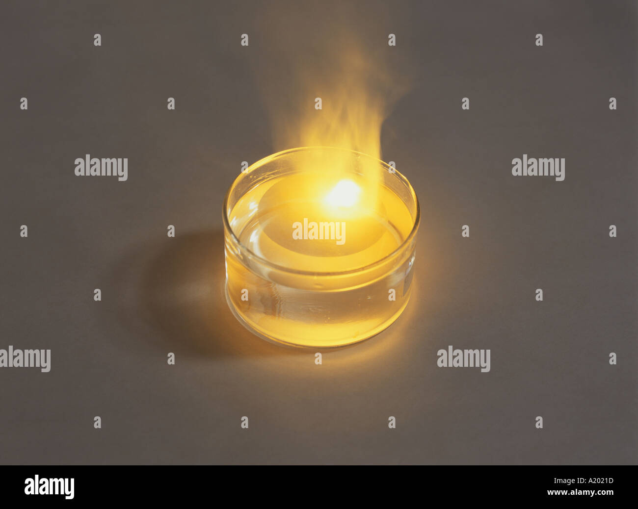 Metallisches Natrium (Na), das in einer Glasschüssel stark auf Wasser brennt und eine hellgelbe Flamme erzeugt. Siehe auch A2021E Stockfoto