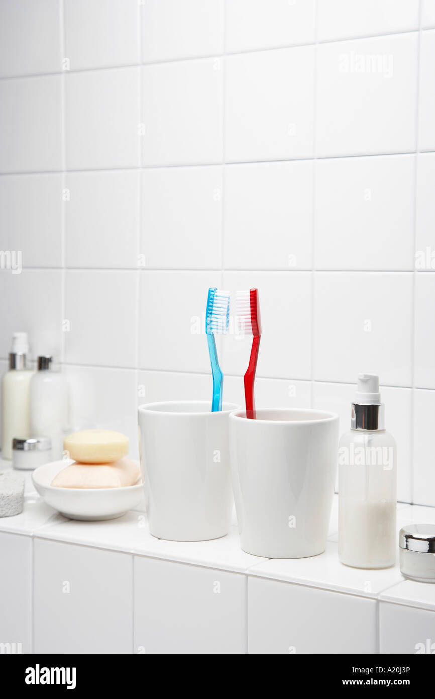 Zahnbürsten von Angesicht zu Angesicht auf Regal im weißen Badezimmer Stockfoto
