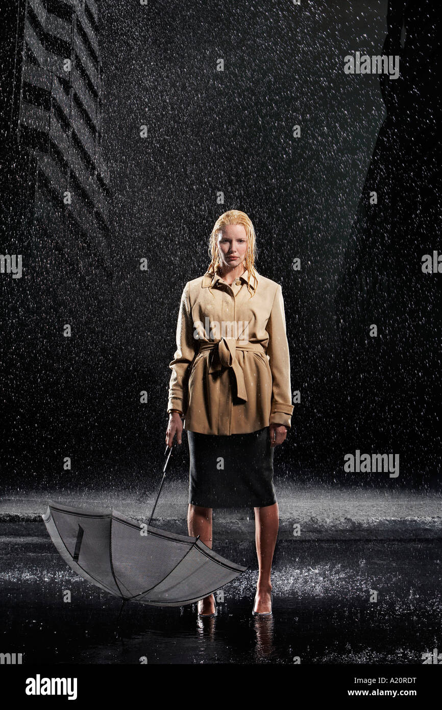 Frau im Regen stehen, nicht mit ihrem Schirm Stockfoto