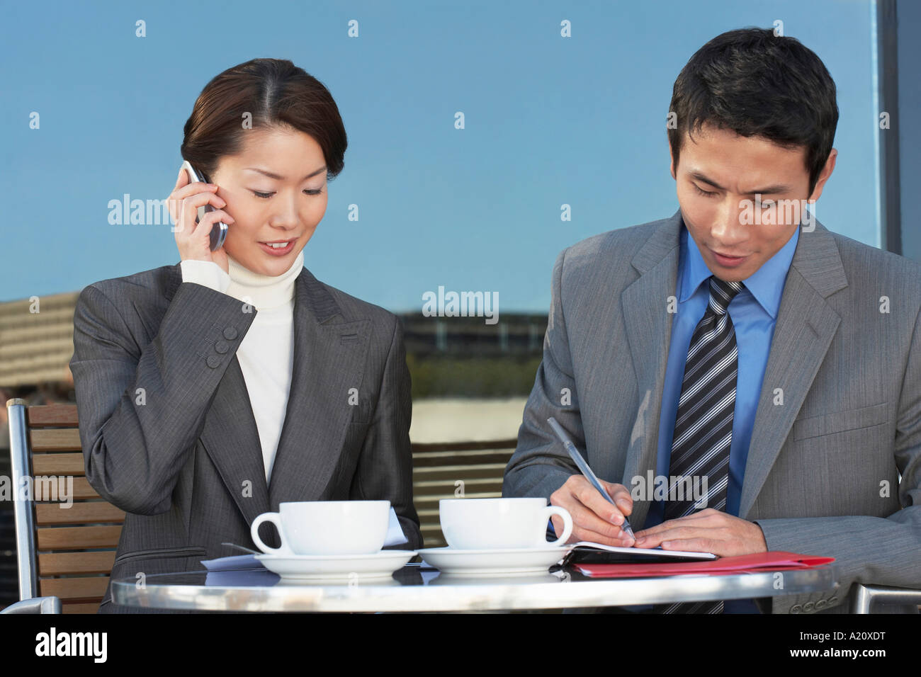Unternehmer treffen im Café im Freien, telefonieren, überprüfen von Dokumenten Stockfoto