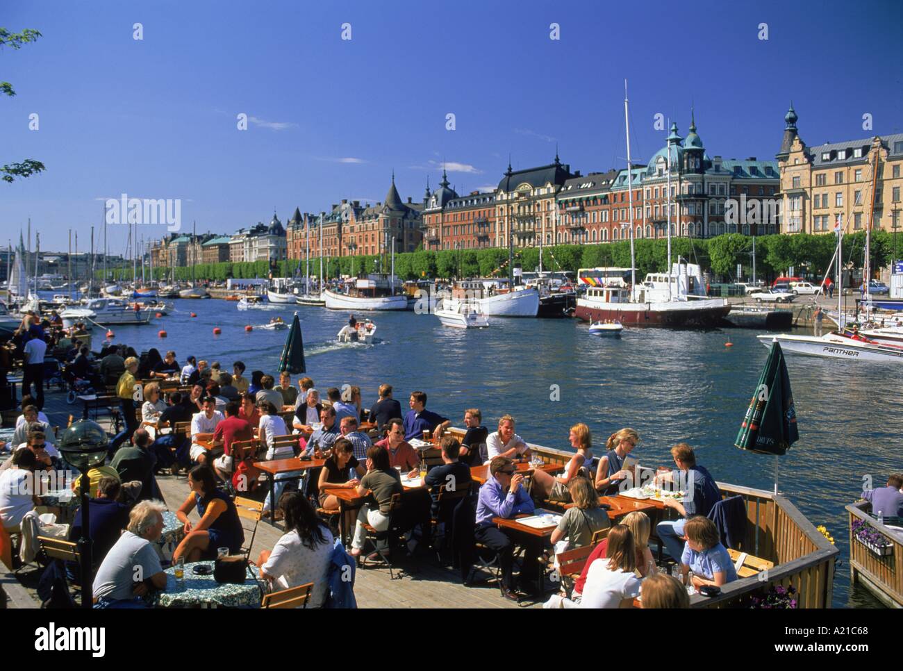 Open-Air-Café an der Blickrichtung Uferpromenade mit Booten und Gebäude der Stadt-Zentrum in Stockholm Schweden D Maxwell Stockfoto