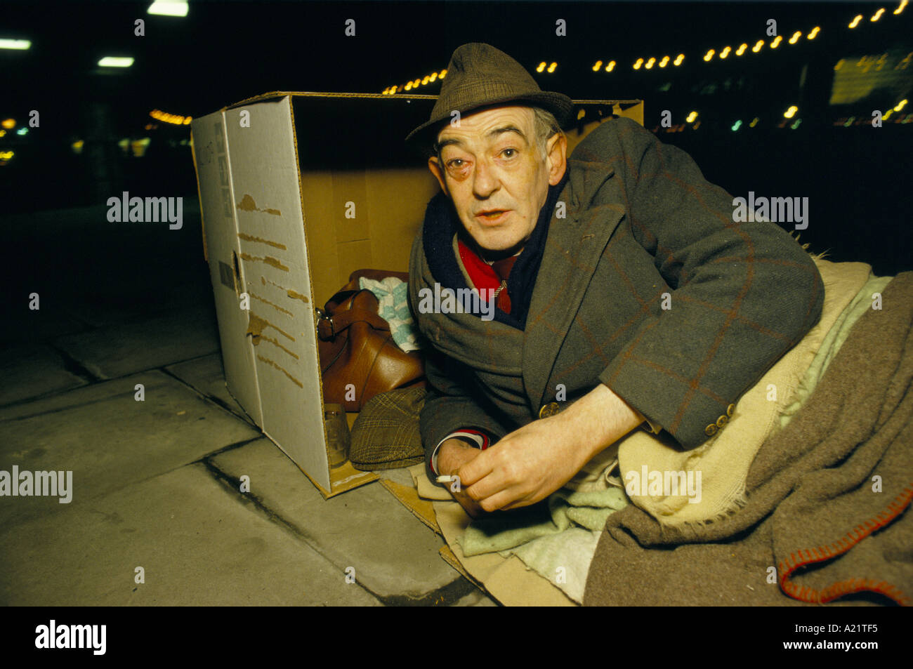 Ein Obdachloser mit einem blauen Auge schlafen rau hinter einem Karton in der Royal Festival Hall, London Stockfoto