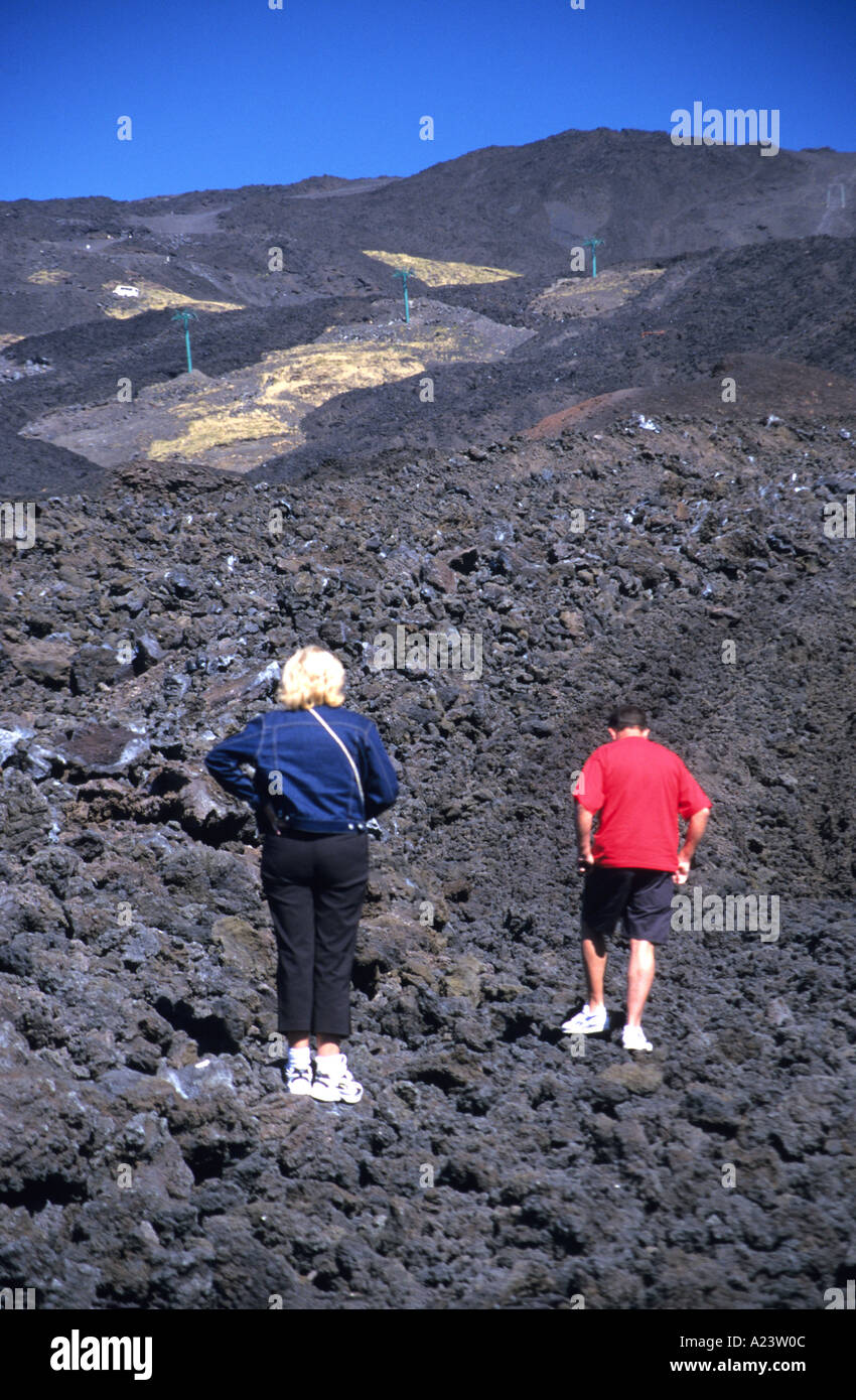 Touristen erkunden die Lavafelder des Ätna nach einem Vulkanausbruch. Stockfoto