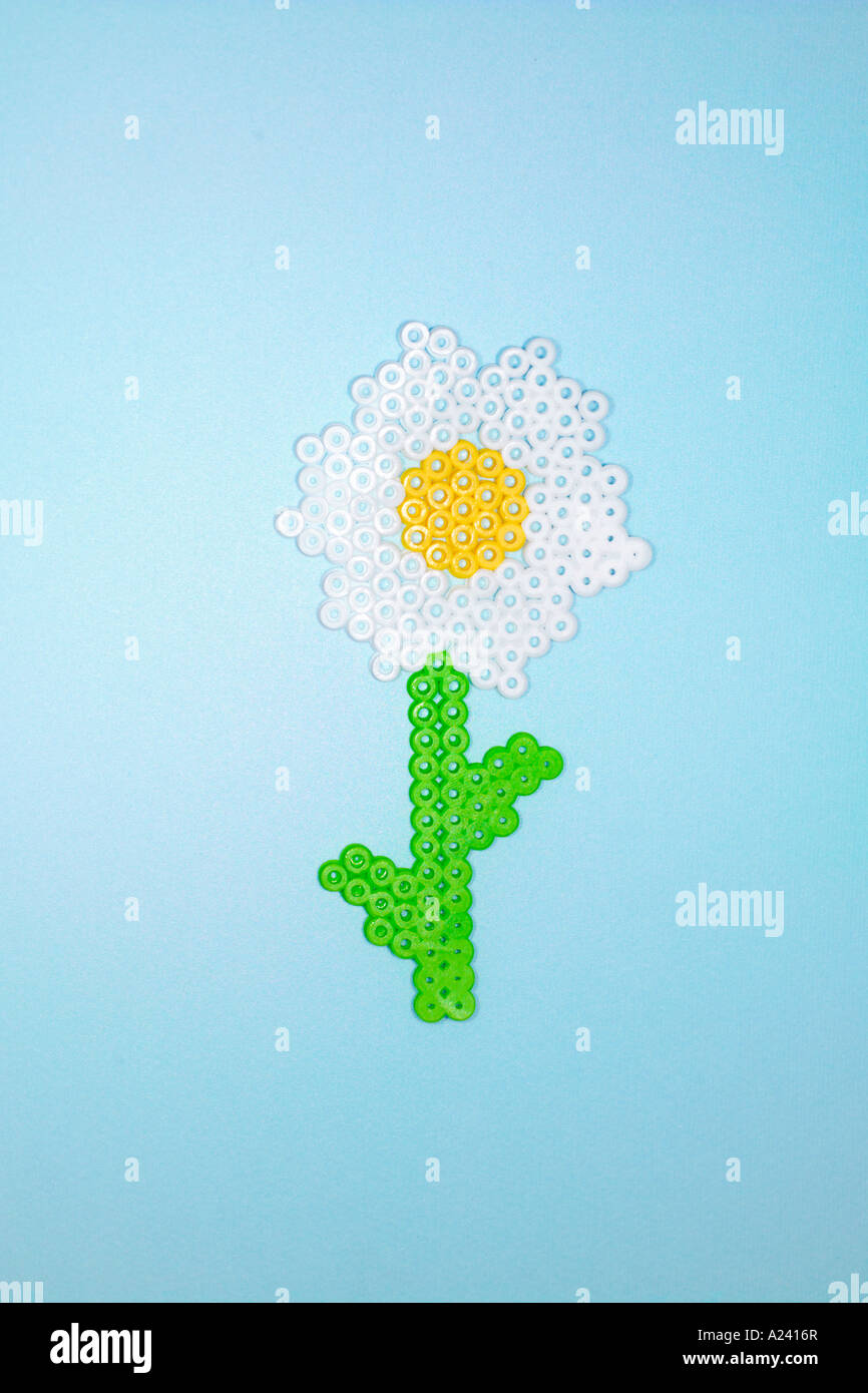 Kunststoff Blume aus Perler Perlen auf blauem Grund hergestellt. Stockfoto