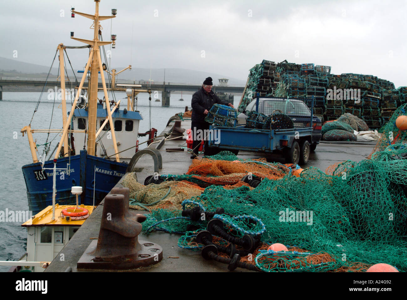 Portmagee westlichen Irland Irland EU Fischer bereitet Hummer Töpfe auf dem Kai bei nassem Wetter Stockfoto