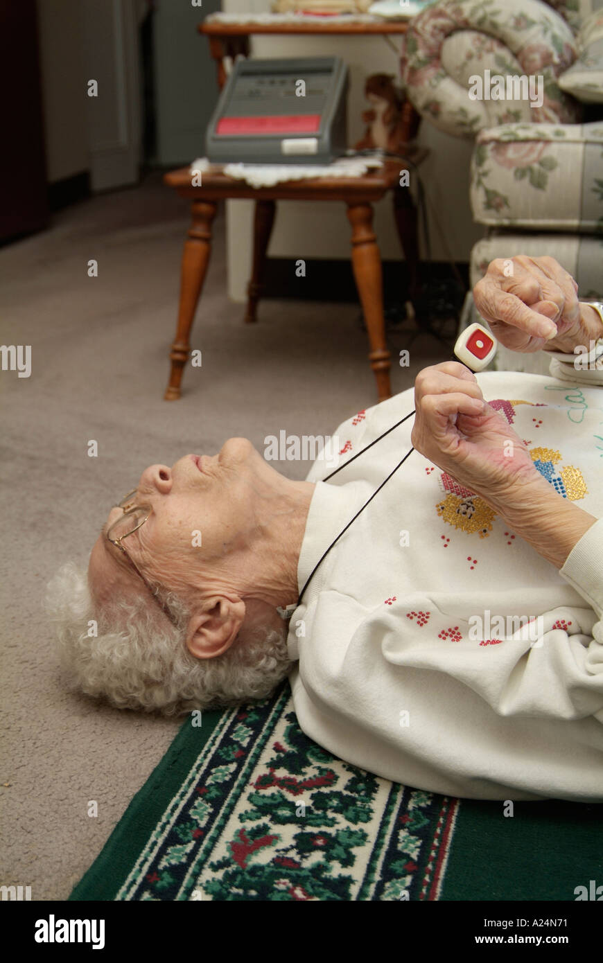 Senioren weiblich verwendet eine medizinische Alarm Alarmanlage für Notruf für Hilfe nach einem Sturz Stockfoto