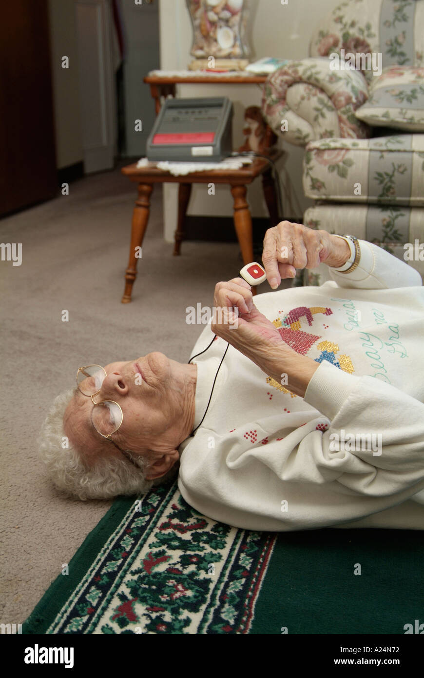 Ältere Frauen verwenden ein medizinisches Alarmsystem für Notrufe nach einem Sturz bei einem Unfall Stockfoto