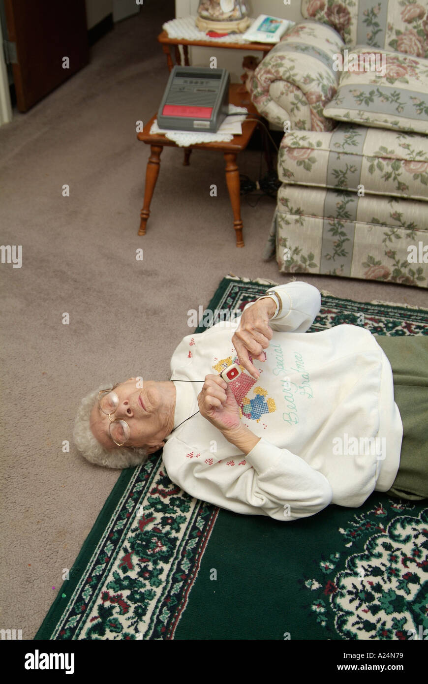 Senioren weiblich verwendet eine medizinische Alarm Alarmanlage für Notruf für Hilfe nach einem Sturz Stockfoto