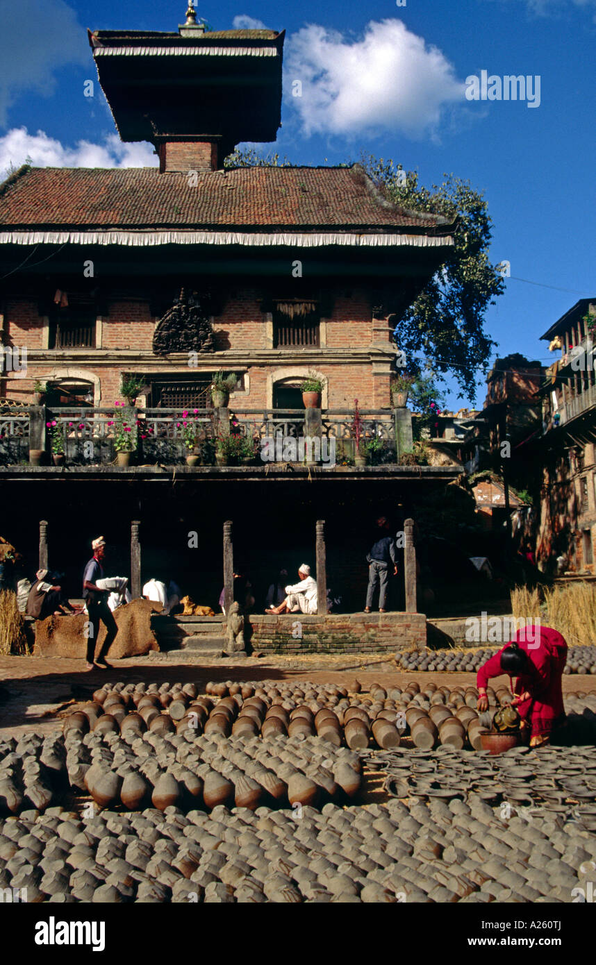 Eine nepalesische Frau trocknet frisch geworfenen TONTÖPFE eins BHAKTAPUR S Hauptprodukte KATHAMANDU Tal NEPAL Stockfoto