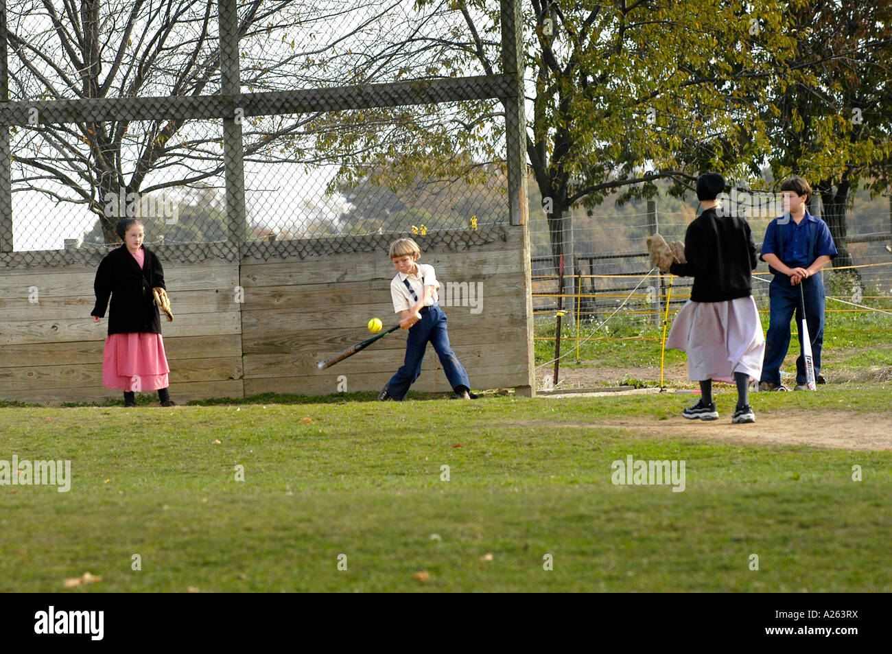 Kinder spielen Baseball Softball in Schulhof Amish Lifestyle in und um Sugarcreek und Millersburg Ohio OH Stockfoto