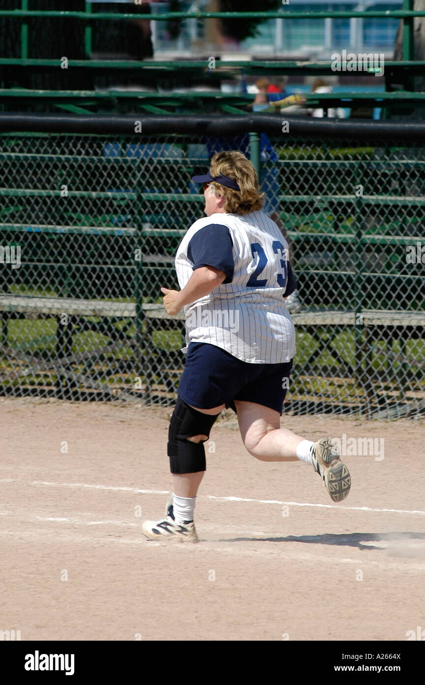 Weibchen mit einer Klammer auf dem verletzten Knie laufen mit Übergewicht Stockfoto