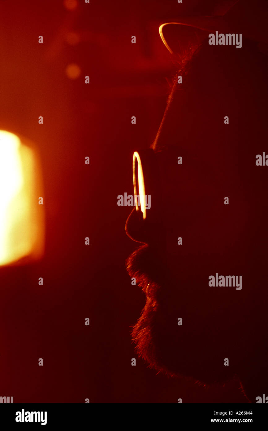 Ein Arbeiter in Sicherheit Schutzbrillen und ein Hut blickt in einem glühenden Ofen wie eine Legierung geschmolzen ist. Stockfoto