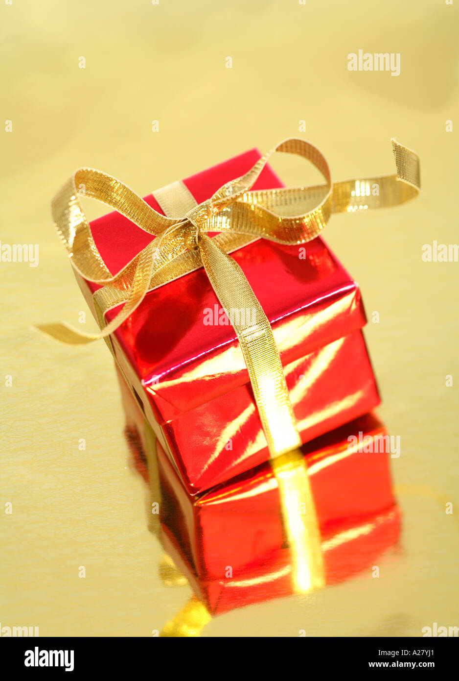 Rotes Geschenk mit Goldband auf gold reflektierenden Hintergrund Stockfoto