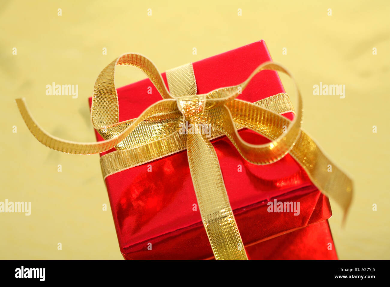 Rotes Geschenk mit Goldband auf Goldgrund Stockfoto