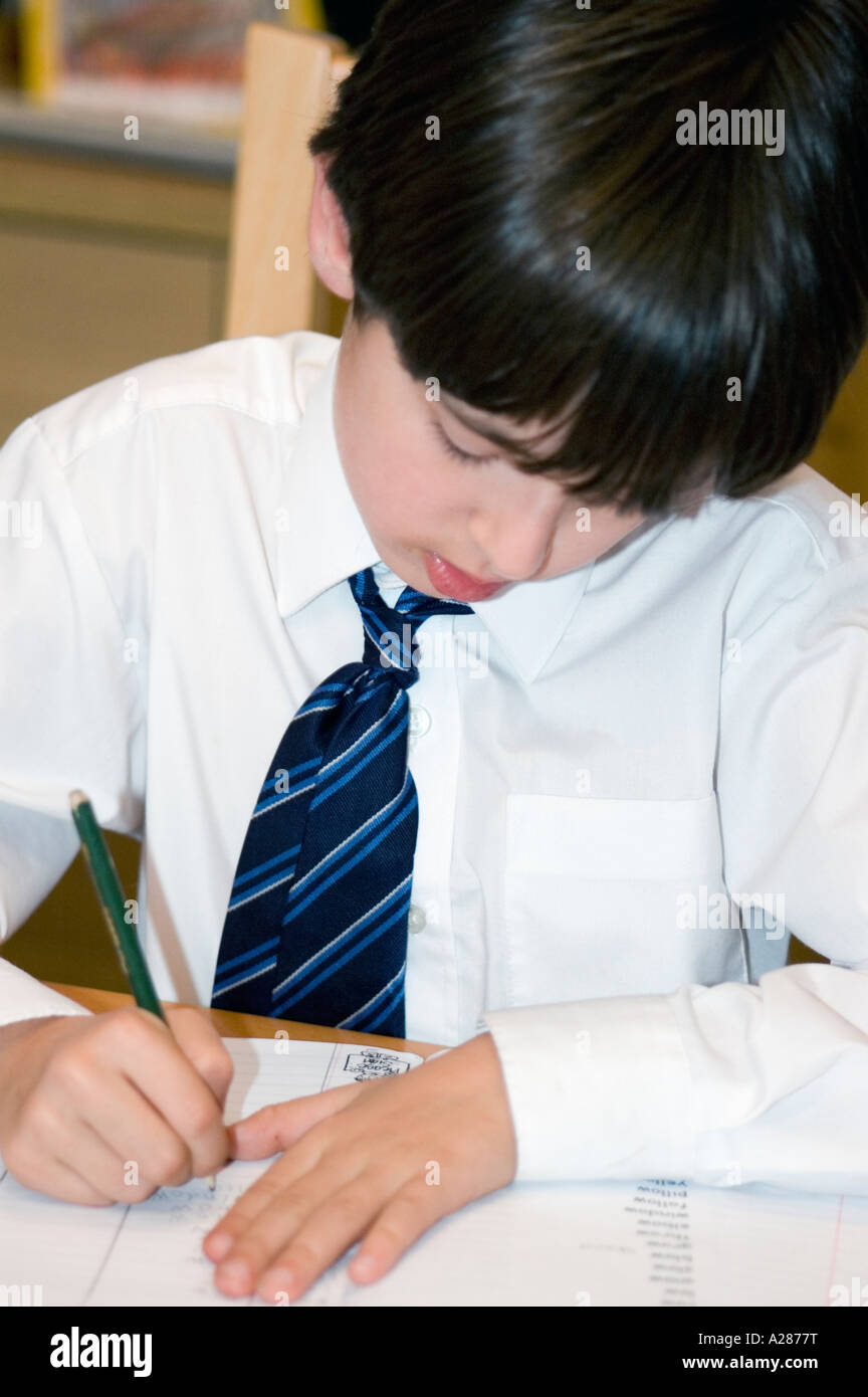 Acht oder neun Jahre alten Schüler sitzen an einem Tisch seine Hausaufgaben Stockfoto