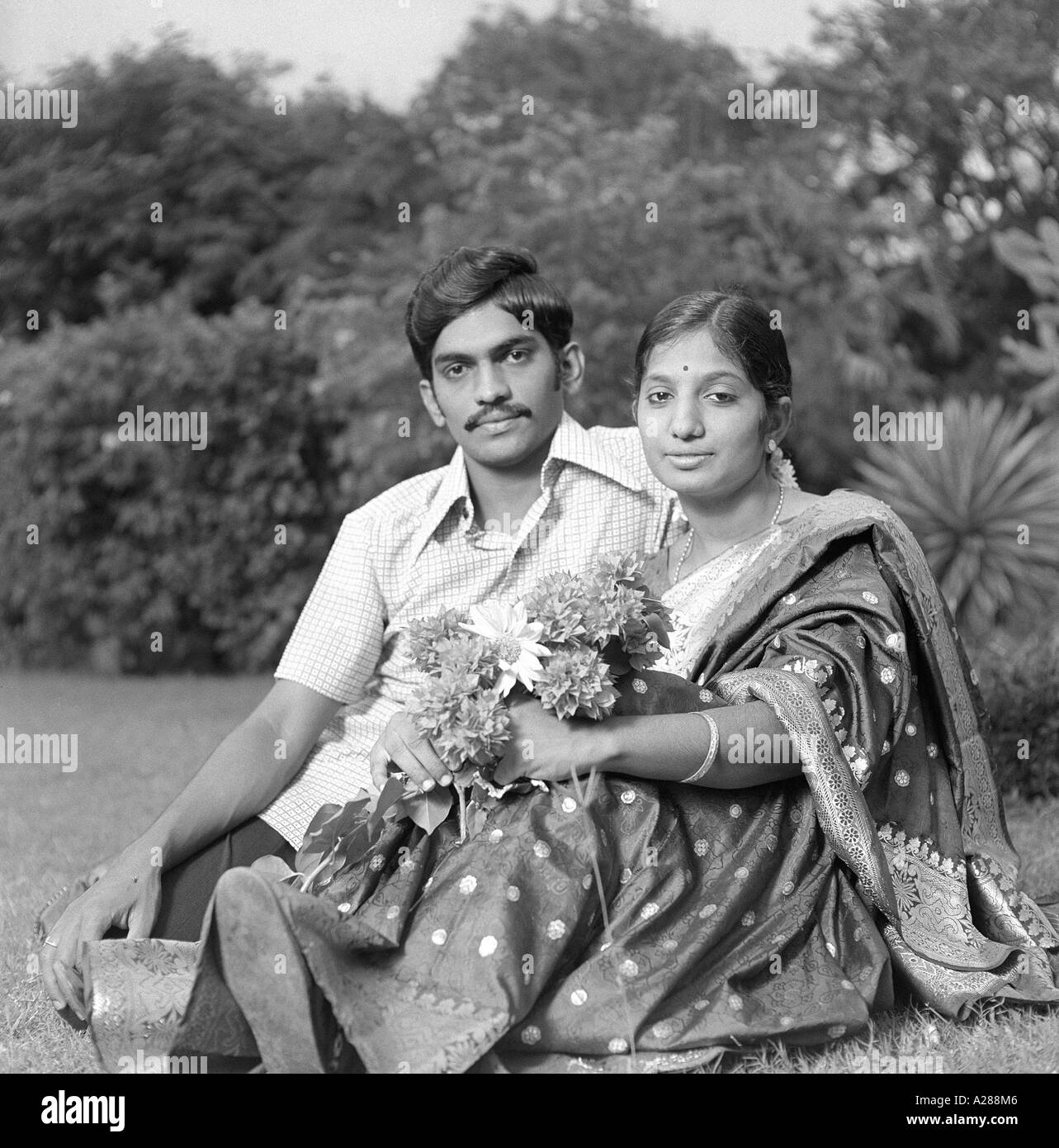 Indischer Mann Frau Mann Frau Paar sitzend liebevoll Garten Indien Asien Indisch Asiatisch alter Jahrgang 1900s Bild MR#777A dpa-76615-maa Stockfoto