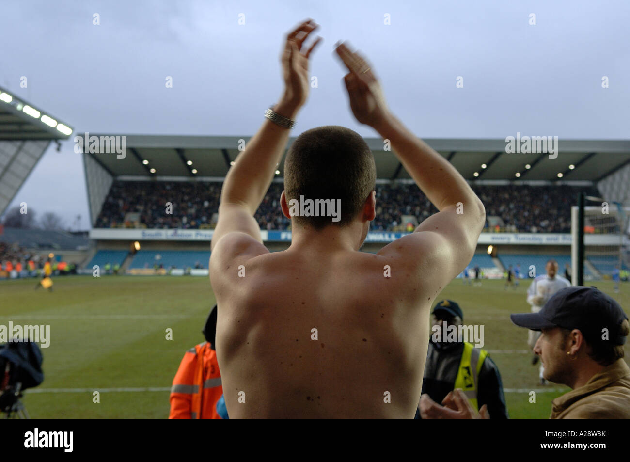 Mann mit kein Top klatschte auf den Terrassen bei Millwall FC Stockfoto